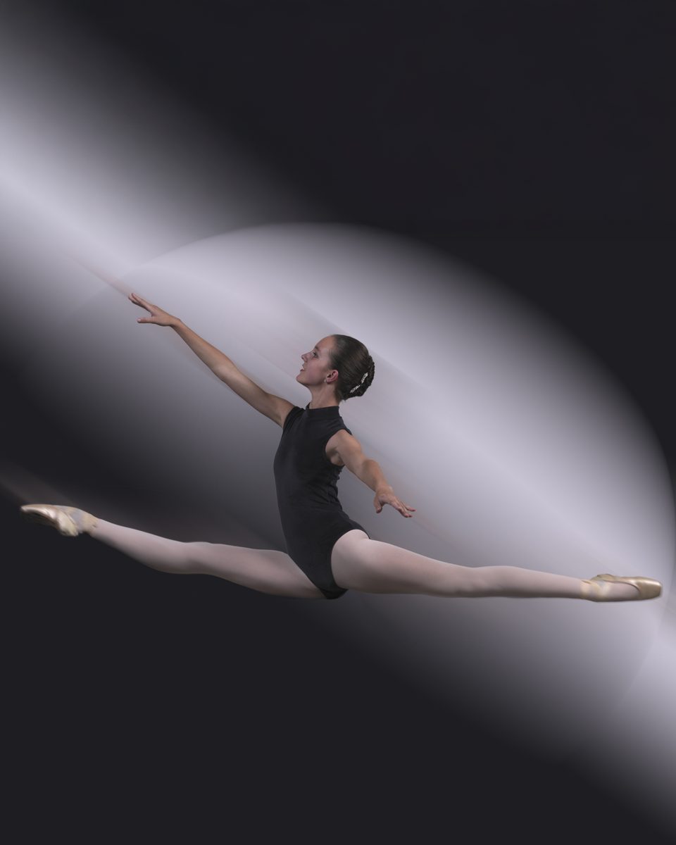 Ingeborg in grand jeté in een zwart balletpak